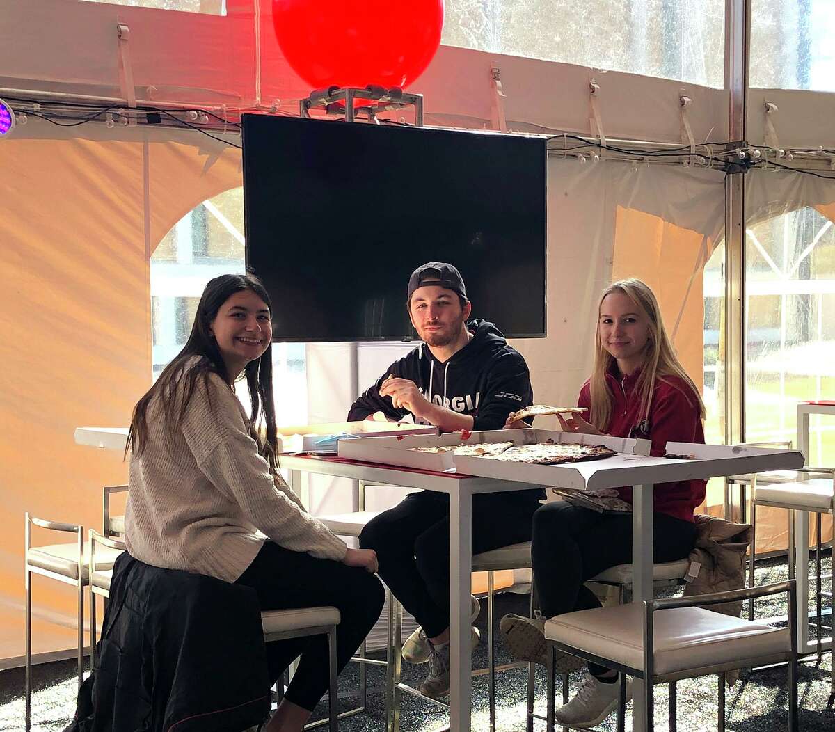 Sacred Heart University students gather in an outdoor tent with 3,500 square feet of space for them to socialize as the school relaxes some of its COVID restrictions.