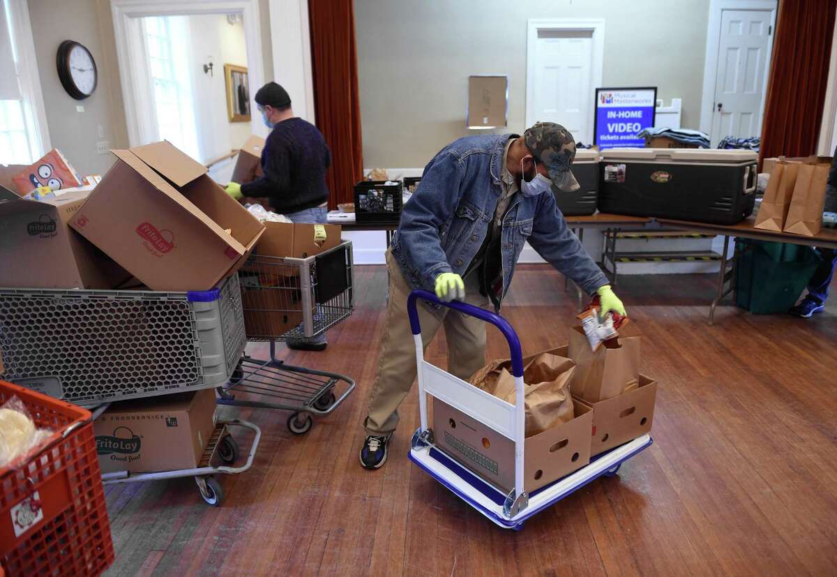 William Jackson of Waterford prepares bags of groceries at a Shoreline Soup Kitchens & Pantries location at the First Congregational Church in Old Lyme on February 27, 2021.
