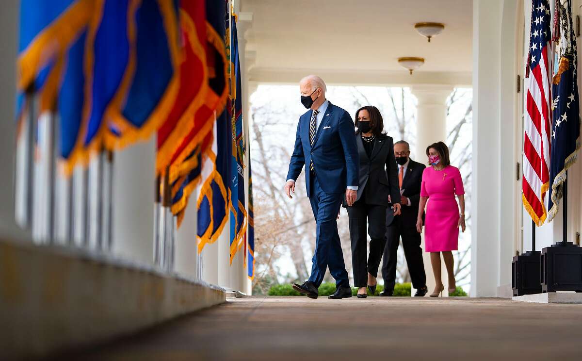 President Biden (left), Vice President Kamala Harris, Senate Majority Leader Chuck Schumer, R-N.Y., and Speaker of the House Nancy Pelosi, D-San Francisco, prepare to deliver remarks on Friday about the stimulus package.