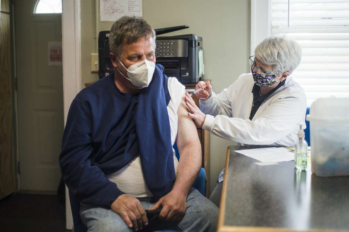 Becky Carlson, a community health nurse with the Midland County Health Department, right, administers the Johnson & Johnson COVID-19 vaccine to Charles Cutcher, left, during a clinic Monday, March 15, 2021 at Midland's Open Door. (Katy Kildee/kkildee@mdn.net)