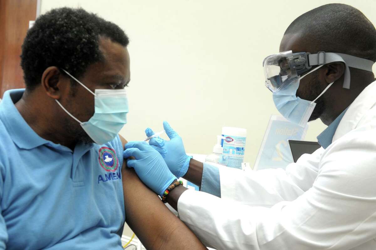 Kent Owusu, right, administers a COVID-19 shot to Dammy Bamisile, of Stratford, at the vaccination clinic at the Cathedral of the Holy Spirit, in Bridgeport, Conn. March 15, 2021.