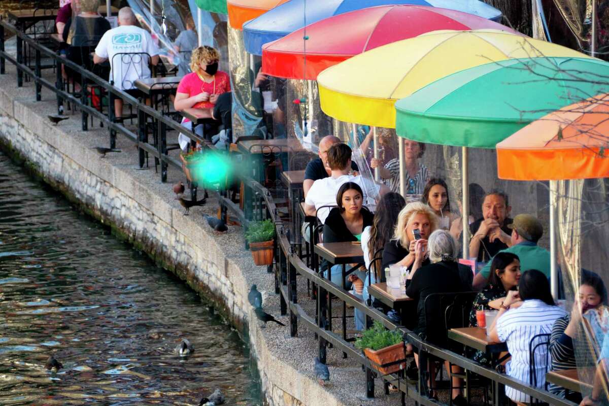 People dine at Casa Rio on the River Walk on Friday, March 5, 2021. The tables are separated by clear partitions.
