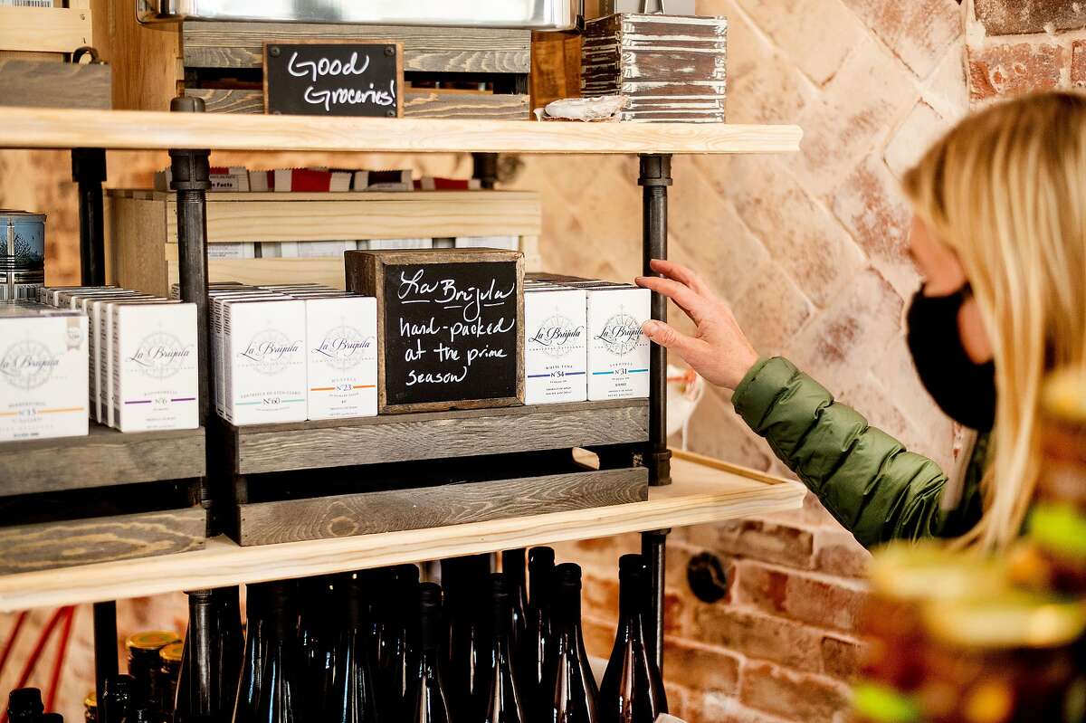 A shopper selects a box of La Brujula sardines at Billingsgate in San Francisco.