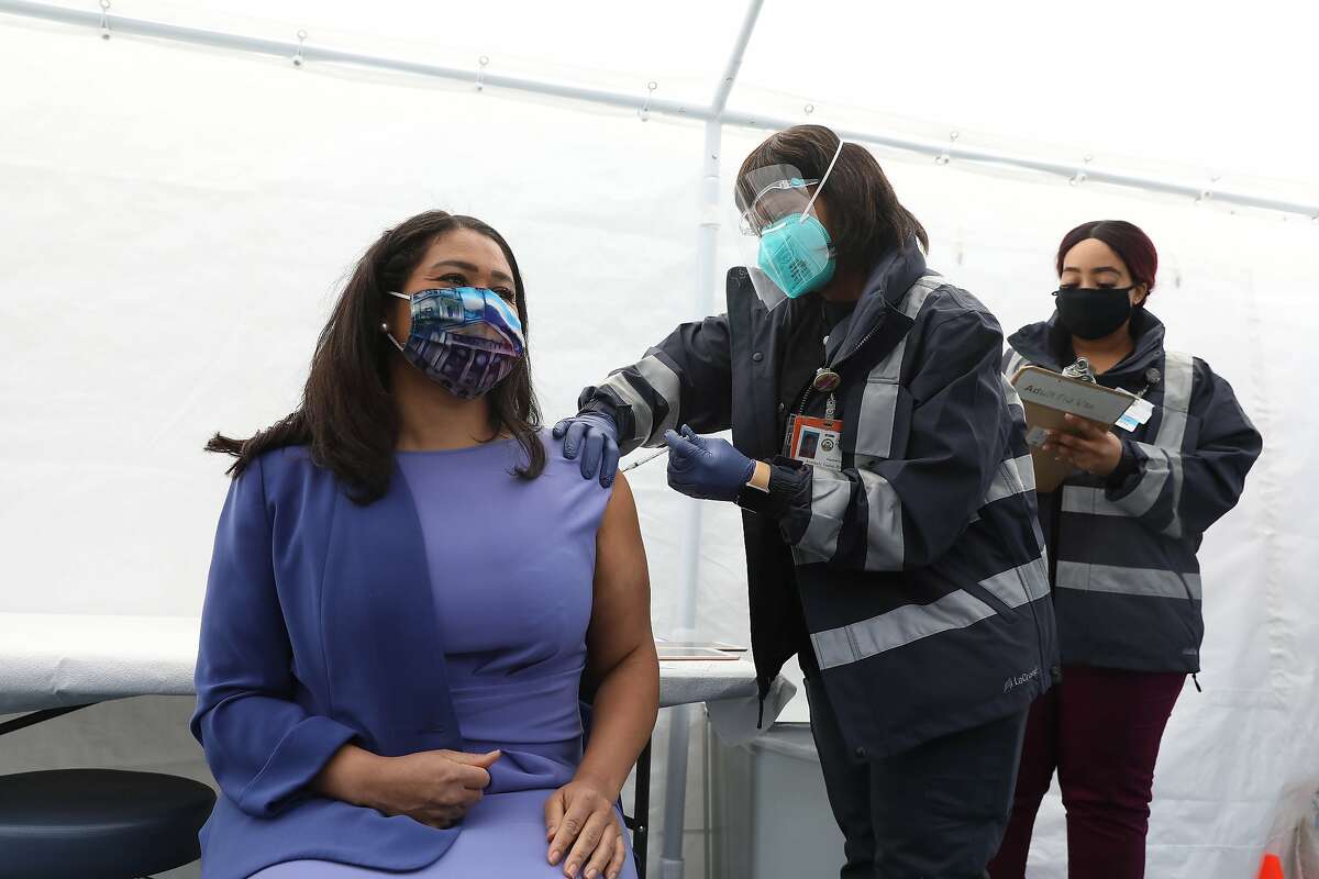 Kimberly Tucker (right), SFDPH nurse, gives Mayor London Breed (left) the Johnson and Johnson COVID-19 vaccine at a vaccine clinic at Maxine Hall Health Center on Tuesday in San Francisco. Tucker’s daughter was a childhood friend of Mayor Breed.