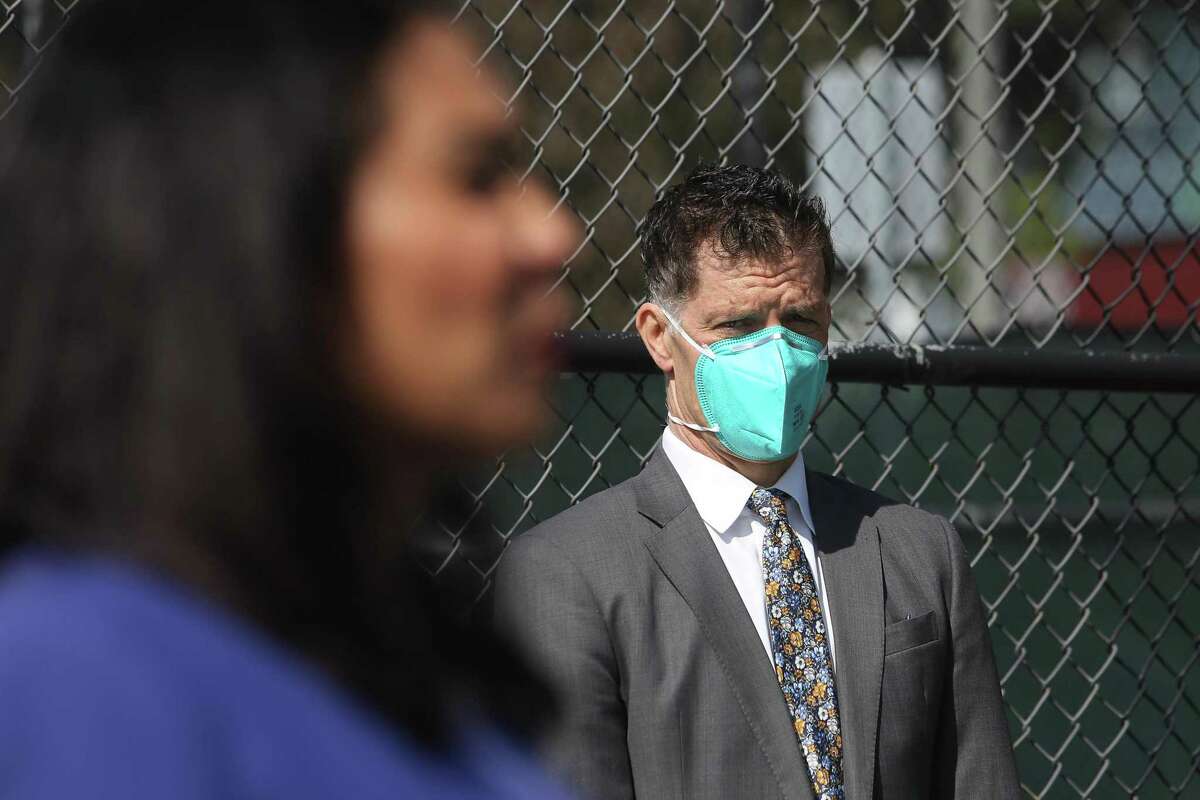 Dr. Grant Colfax (right) San Francisco’s director of health, listens as Mayor London Breed (left) speaks to media at Maxine Hall Health Center before she gets the Johnson and Johnson COVID-19 vaccine on Tuesday.