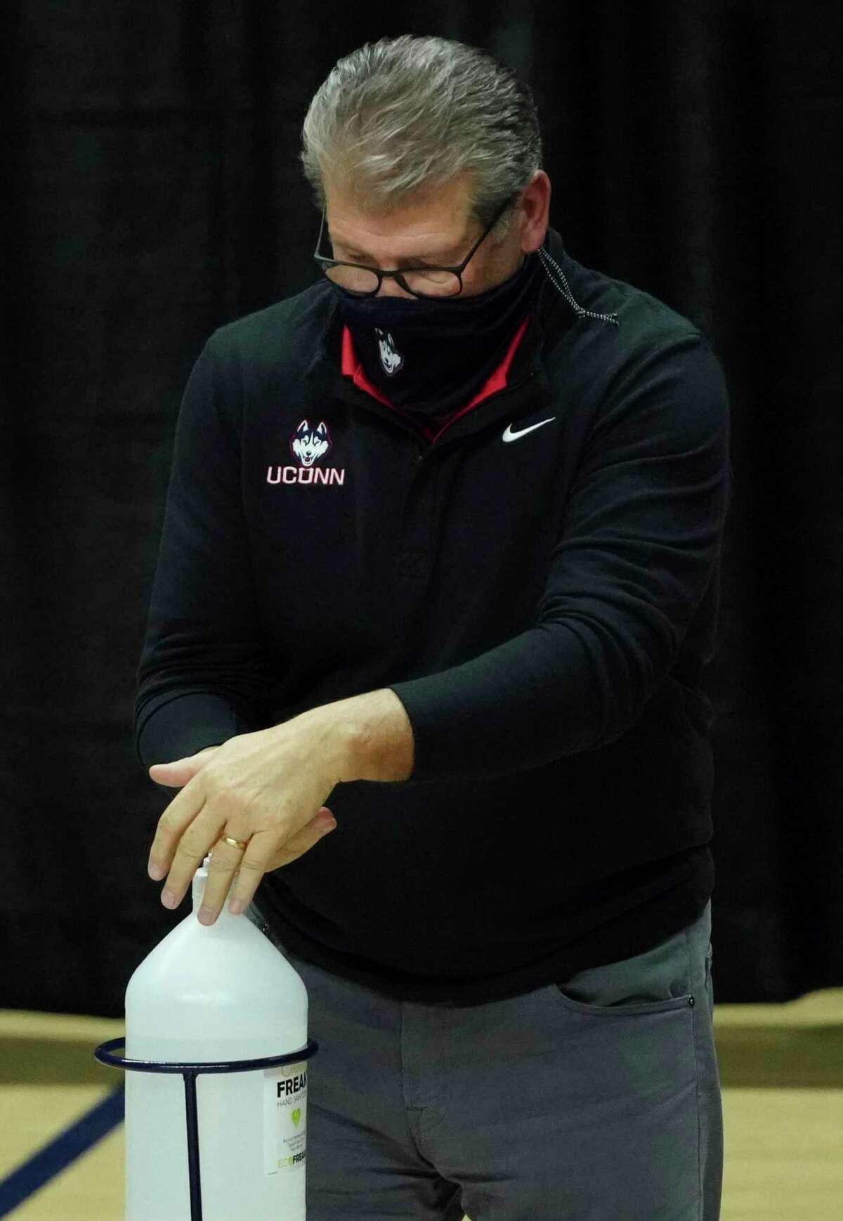 UConn women’s basketball coach Geno Auriemma uses hand sanitizer as his team takes on Providence in January. Auriemma has tested positive for COVID-19 despite receiving two doses of the coronavirus vaccination.