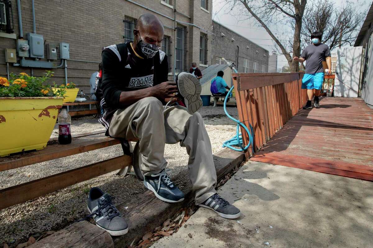 Andrew Wright, who has been living in a tent near the Interstate 37 overpass, tries on a new pair of shoes he received at an outreach event on March 16, 2021, at Christian Assistance Ministry near downtown San Antonio.