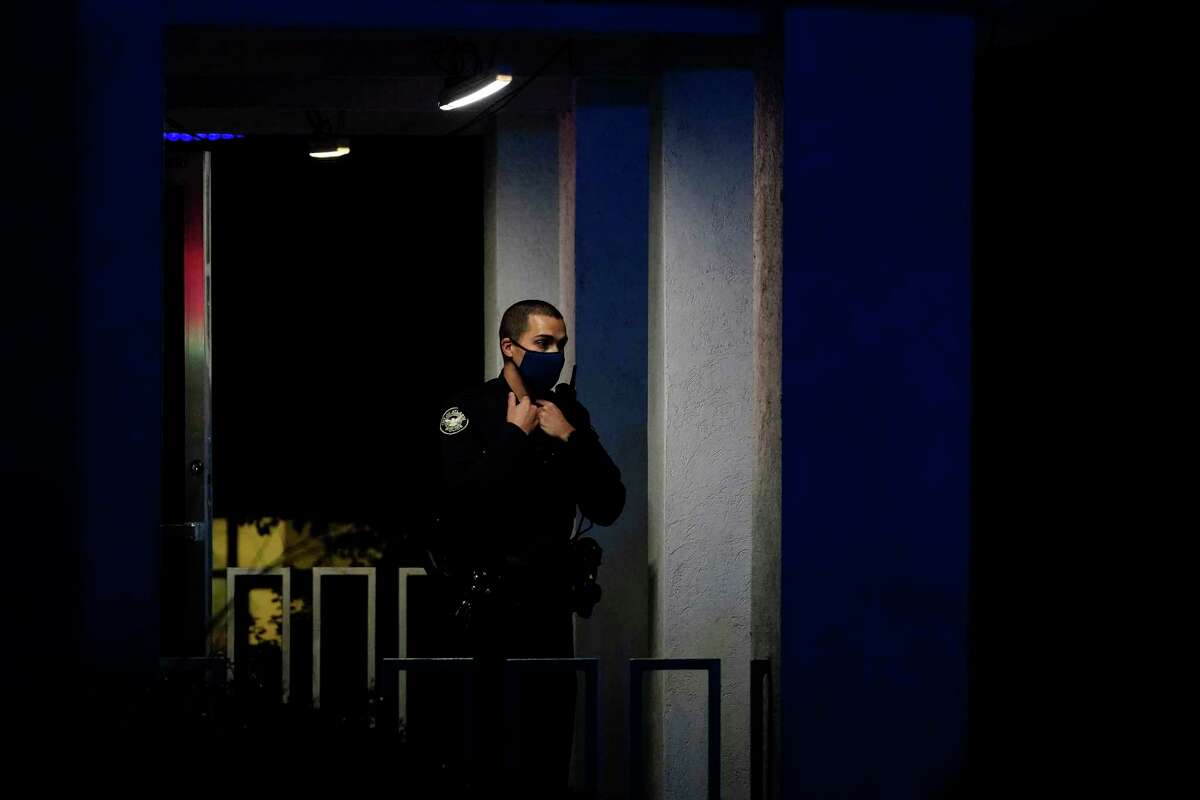 An officer stands outside Gold Spa after a shooting, late Tuesday, March 16, 2021, in Atlanta. Shootings at two massage parlors in Atlanta and one in the suburbs left multiple people dead, many of them women of Asian descent, authorities said. A 21-year-old man suspected in the shootings was taken into custody in southwest Georgia hours later after a manhunt, police said.