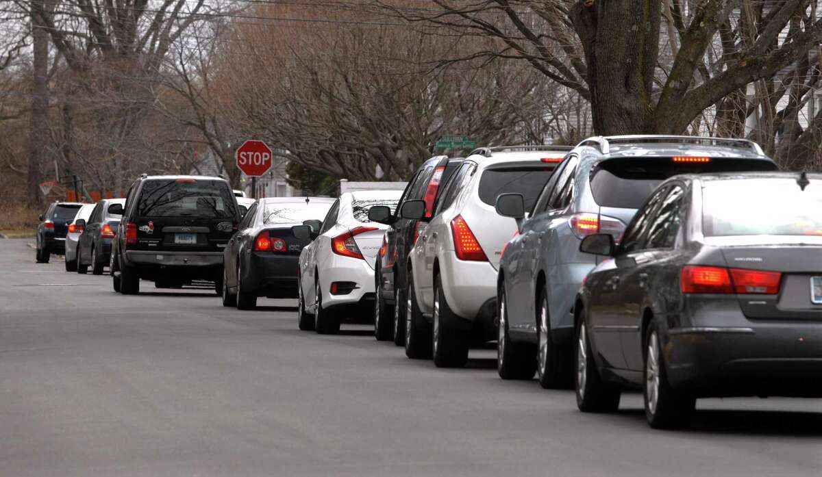Cars are backed up to Oldfield Road waiting in line for lunches of corned beef and cabbage at a special St. Patrick's Day drive-thru luncheon at The Bigelow Center for Senior Activities in Fairfield, Conn., on Tuesday Mar. 16, 2021.