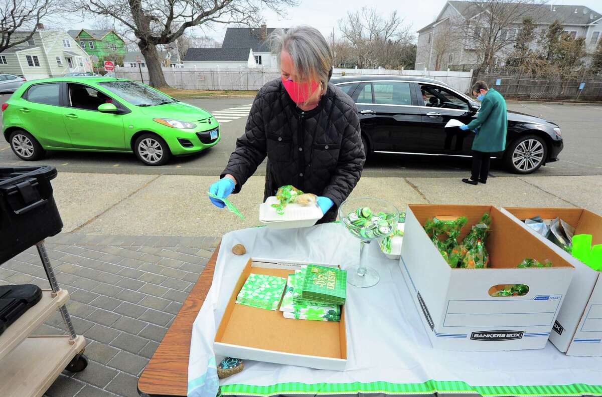 Bigelow Center for Senior Activities Social Services Director Julie DeMarco hands out free lunches of corned beef and cabbage, which were boxed up and handed out for a special St. Patrick's Day drive-thru luncheon at the center in Fairfield on Tuesday.