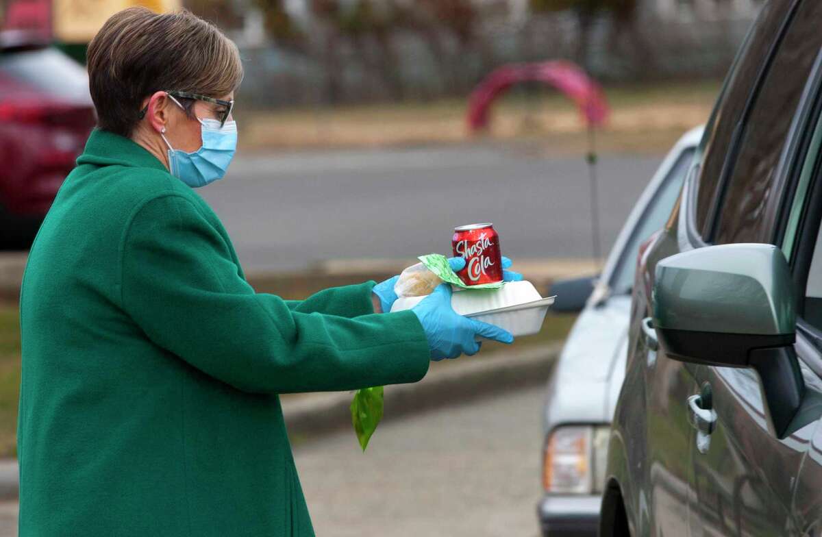 Bigelow Center for Senior Activities Director Brenda Steele, hands out free lunches of corned beef and cabbage, which were boxed up and handed out for a special St. Patrick's Day drive-thru luncheon at the center in Fairfield, Conn., on Tuesday Mar. 16, 2021.