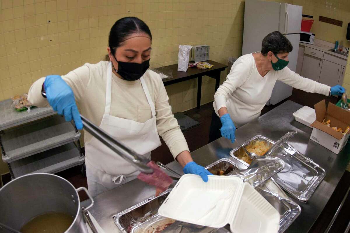 Sandy Atemiz prepares lunches of corned beef and cabbage, which were boxed up and handed out for a special St. Patrick's Day drive-thru luncheon at The Bigelow Center for Senior Activities in Fairfield, Conn., on Tuesday Mar. 16, 2021.