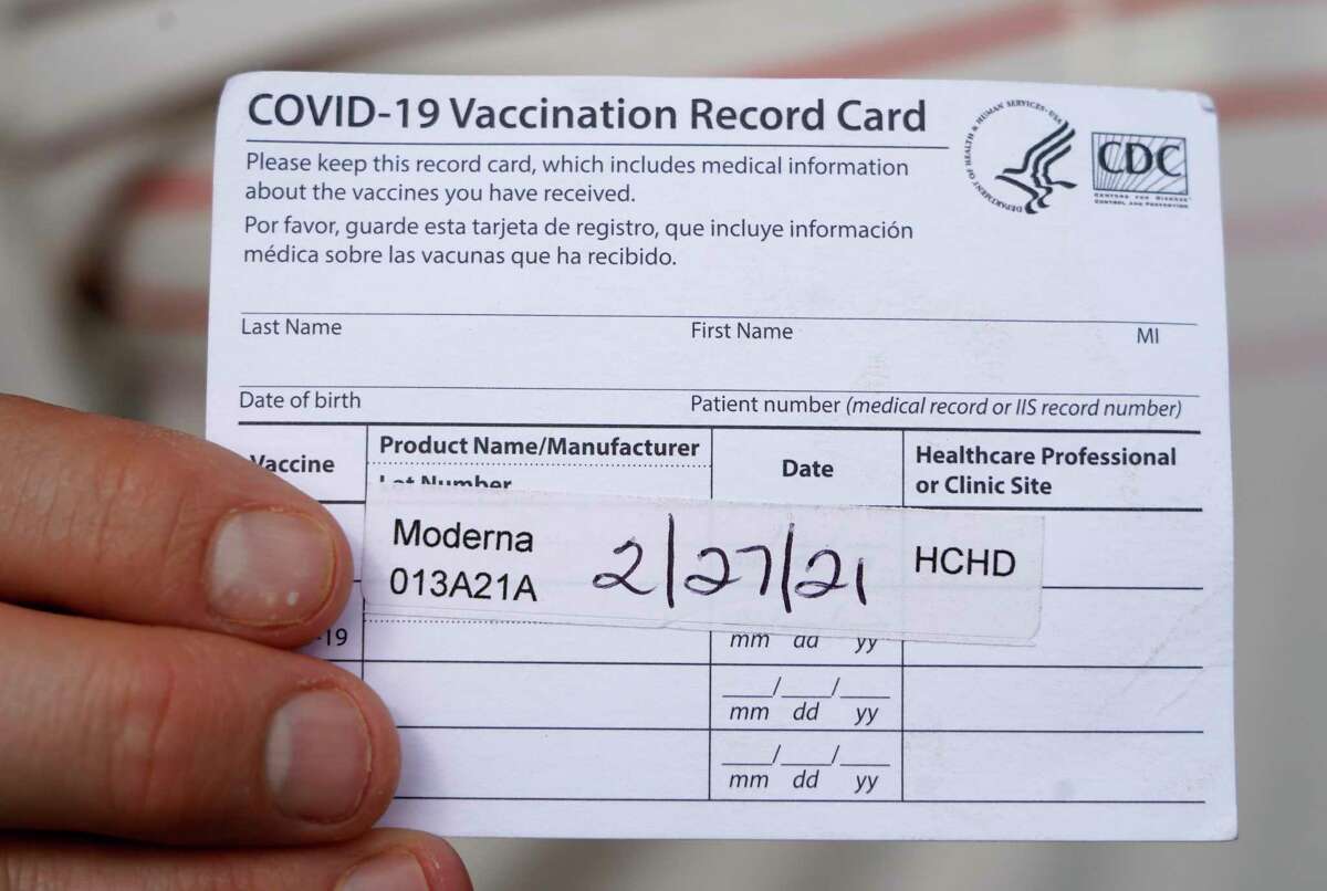 Lennie Ambrose holds his record card for the COVID-19 vaccination that he received from the Hardin County Health Dept. is shown at his home Monday, March 15, 2021 in Houston. He and his wife, Amber Ambrose, went to Lumberton in Hardin County to get their vaccine in late February, and will make the return trip this month.