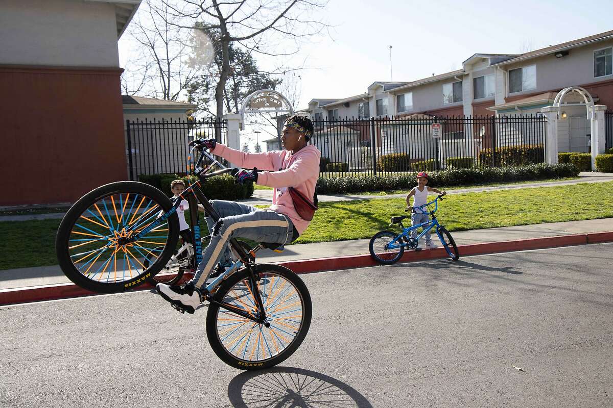 A boy does a wheelie near the Coliseum in Oakland. Moderna announced it is conducting vaccine studies with children up to 12, and Pfizer is doing adolescent trials of its vaccine, with Bay Area participants.