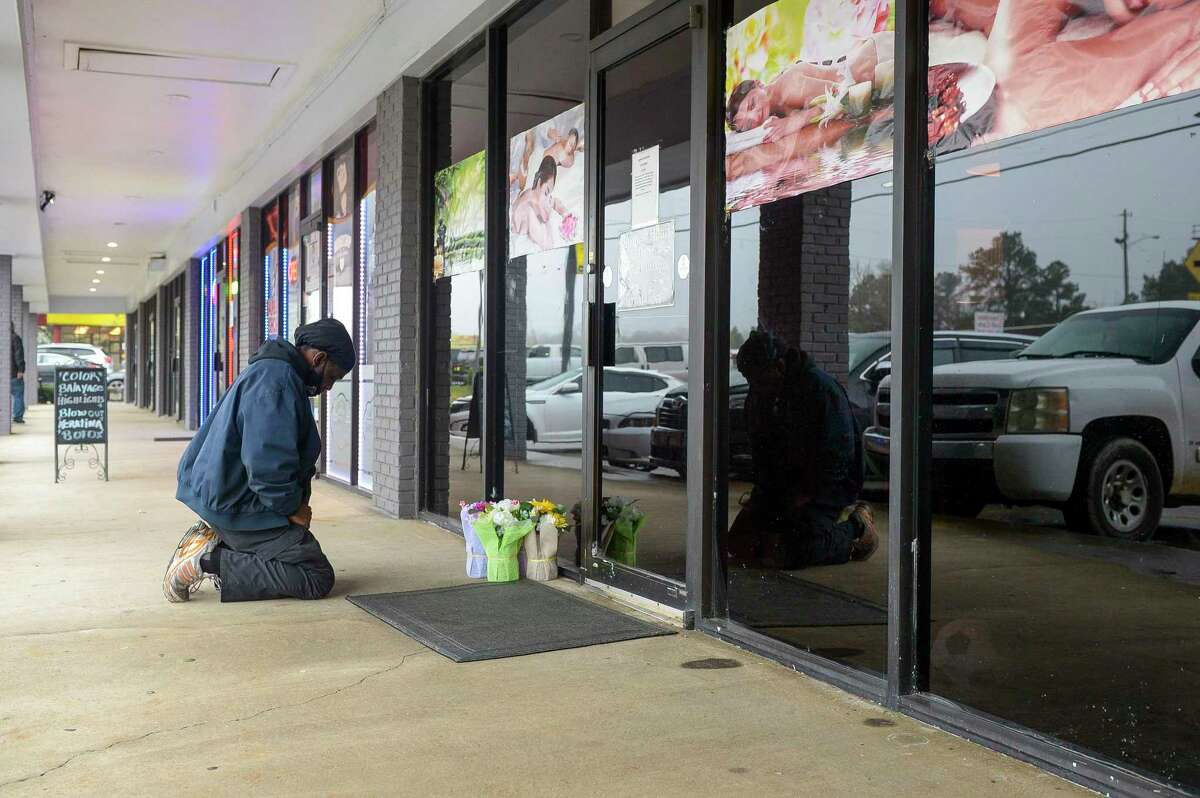 Acworth resident Derrick Franklin places flowers near the entrance of Youngs Asian Massage Parlor Wednesday, March 17, 2021 in Cherokee County, Georgia. Franklin, who works nearby in Woodstock, did not know the owners but came to pay his respects after the shooting that left four people dead and one injured at the massage parlor. (Daniel Varnado/Atlanta Journal-Constitution/TNS)