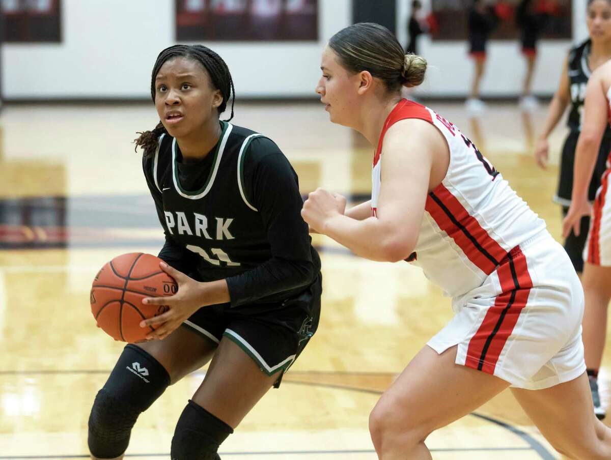 Kingwood Park forward Biva Byrd (21) looks for an opening to shoot for the basket as she's pressured by Porter forward Angelina Khalaf (25) during the first quarter of a District 20-5A girls basketball game at Porter High School, Saturday, Feb. 6, 2021 in Porter.