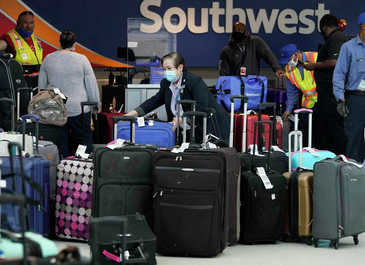 Employees sort luggage for Southwest Airline flights at Hobby Airport Tuesday, Dec. 22, 2020 in Houston.