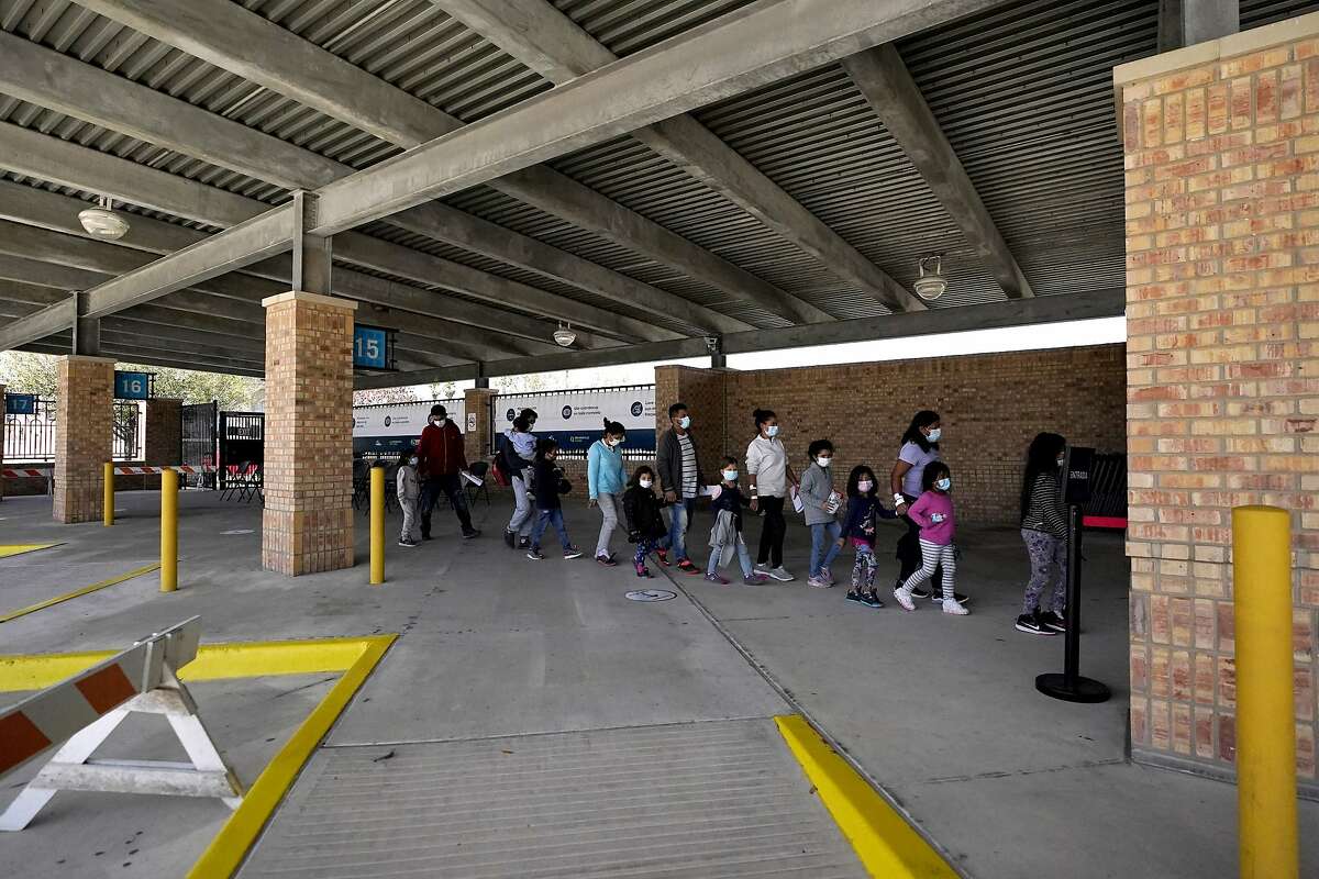 Migrants stand in line after being released from U.S. Customs and Border Protection custody at a bus station Wednesday in Brownsville, Texas.