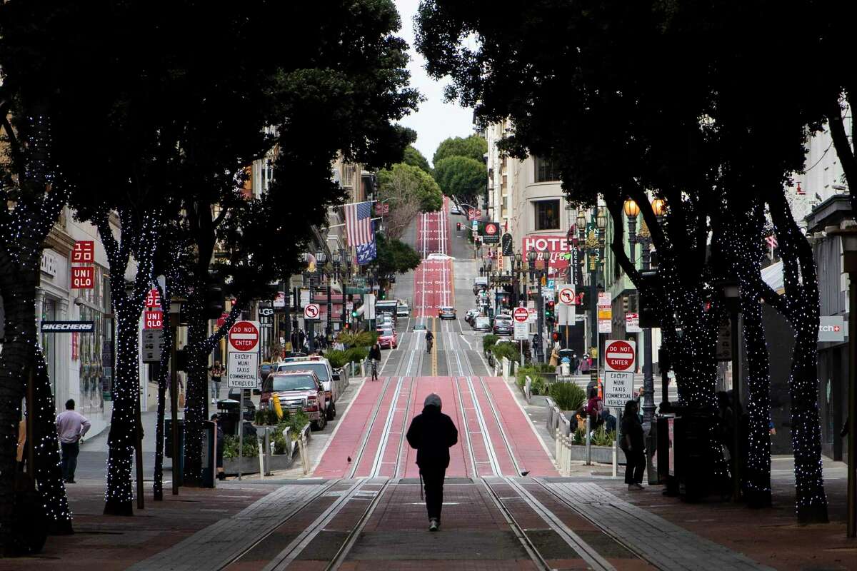 2021年2月18日，在旧金山，一个人走在鲍威尔和市场街的缆车转弯处的空旷轨道上，供人们拍照。根据新的人口普查数据，在大流行的第一部分，旧金山是迄今为止美国主要城市中人口下降幅度最大的城市。