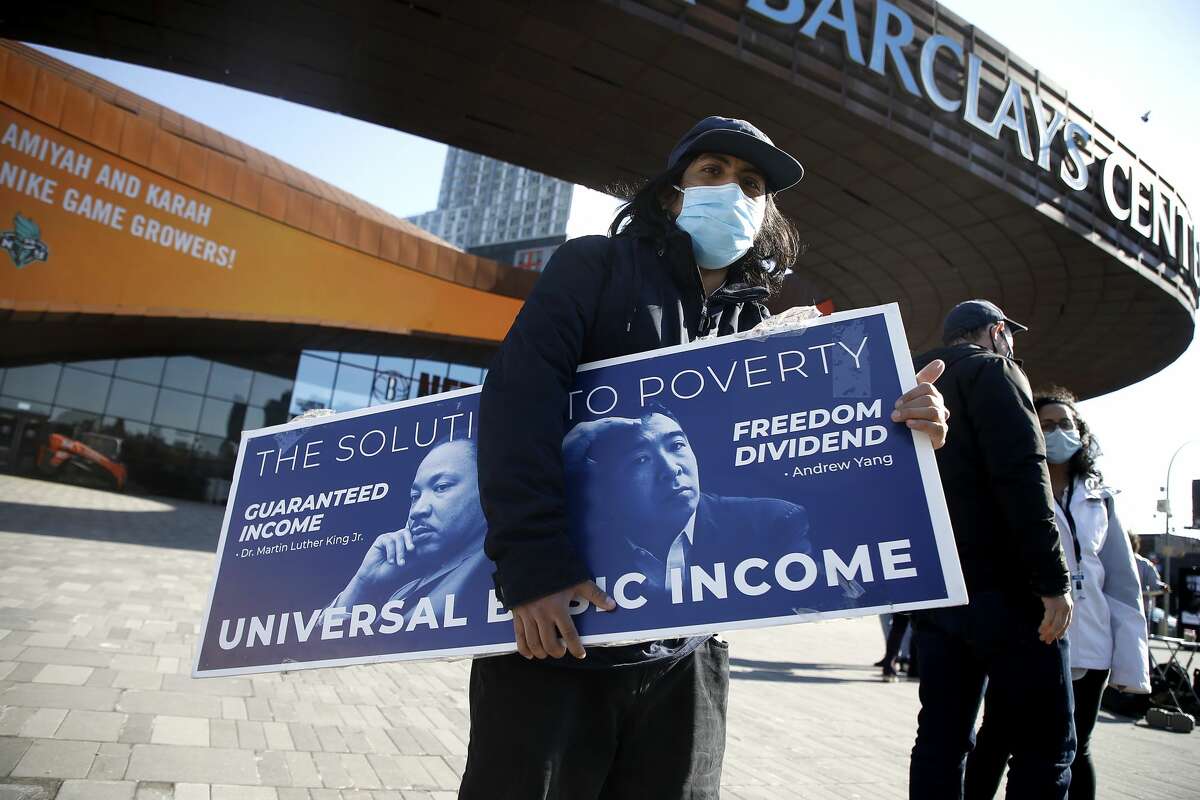 A man holds a campaign sign as New York City mayoral candidate Andrew Yang campaigns at Barclays Center on March 03, 2021 in the Brooklyn borough of New York City. Yang made Universal Basic Income a hallmark of both his 2020 presidential and current mayoral campaigns, and as the pandemic continues, the concept is making a resurgence in communities across the nation like Ulster County.