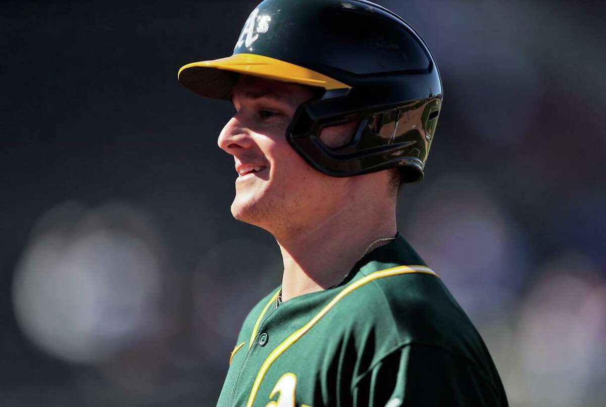Matt Chapman (26) smiles on his way back to the dugout after being lifted for a pinch runner after hitting his fifth inning double, his first hit since recovering from hip surgery, as the Oakland Athletics played the Cincinnati Reds at Hohokam Stadium in Mesa, Ariz., on Monday, March 1, 2021.