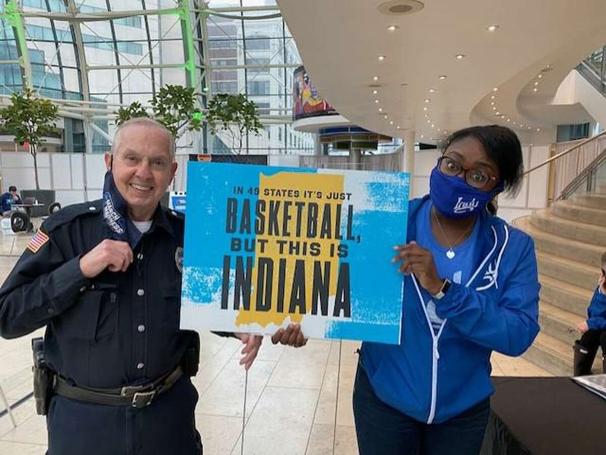 Indiana natives Ron Sullivan, left, and Tierra Bush hold up a sign that emphasizes the Hoosier State's unique love of basketball.