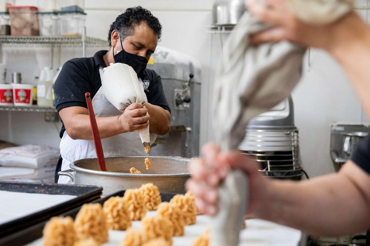 Bakers Epifanio�Garcia (left) and Patty Mondragon prepare macaroons to be baked at Grand Bakery in Oakland, Calif. Monday, March 15, 2021. The Passover recipe featured on Grand Bakery's famous macaroons takes 5 hours to make.The Passover recipe feature on Grand Bakery's famous macaroons takes 5 hours to make.