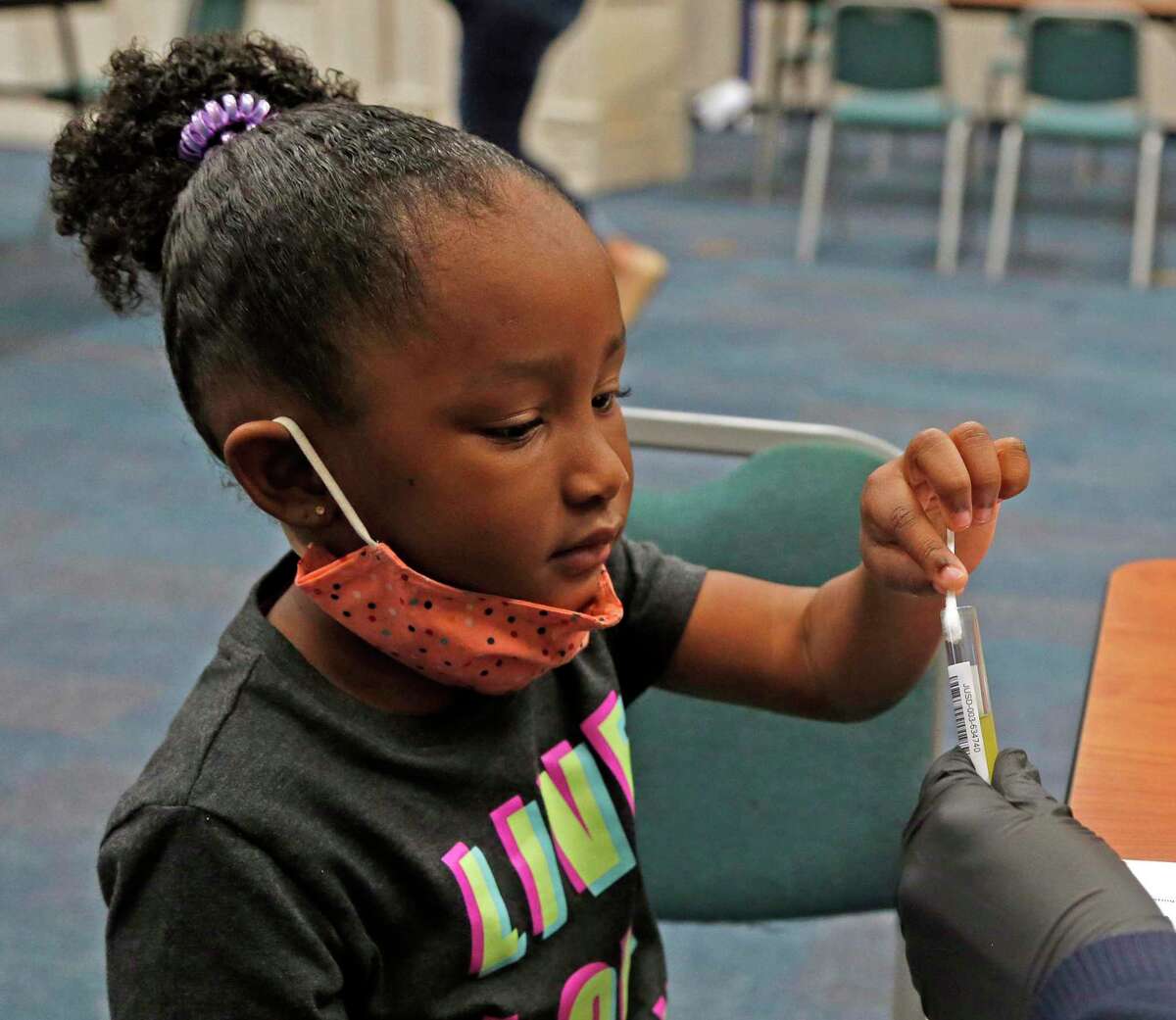 Harleigh Holloway, 4, submits her COVID-19 screening after swabbing her nose. She took part in the nonprofit Community Labs’ weekend COVID-19 testing on March 14 as some local schools prepared to reopen their classrooms after spring break.