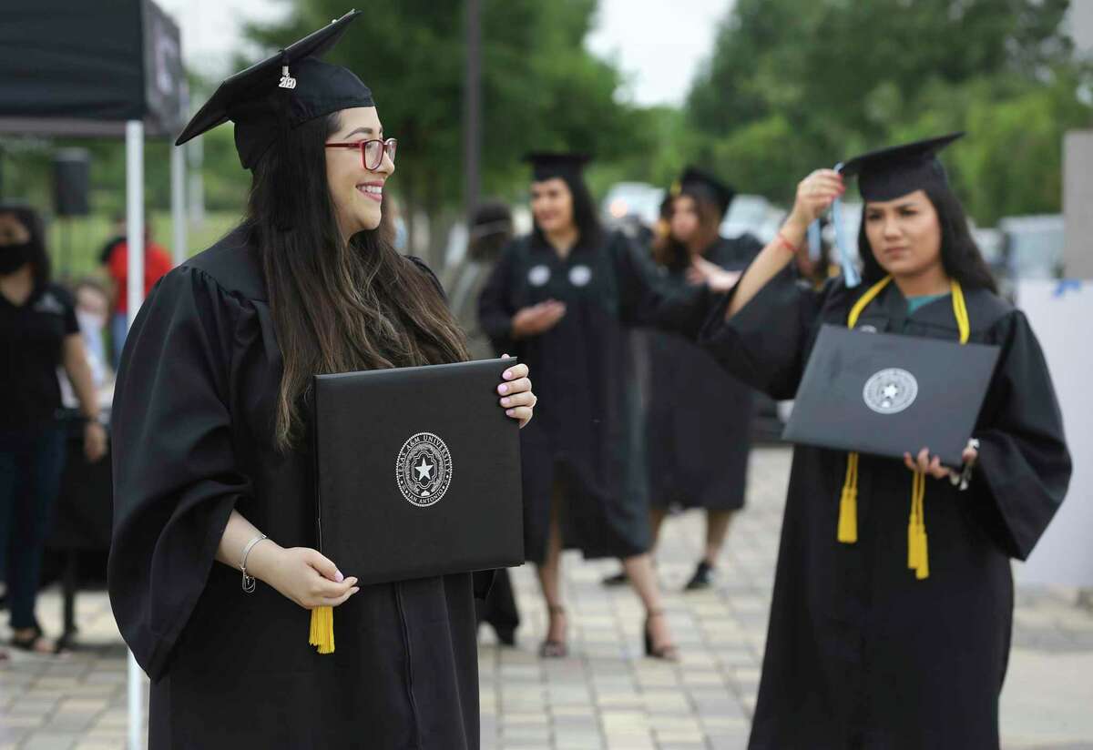 Diana De La Rosa, left, and other graduates wait to have their photos taken with the president of Texas A&M University San Antonio at a curbside gradutation ceremony last May.