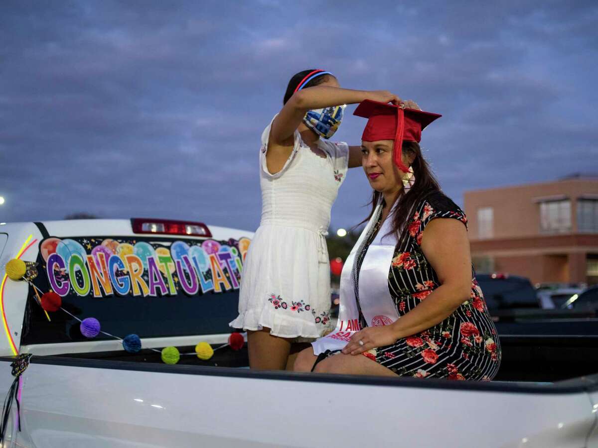 Caprice Diaz, 46, has her graduation tassel fixed to her hat by her daughter, Jessica Diaz, 12, as she celebrates her graduation from San Antonio College last November.