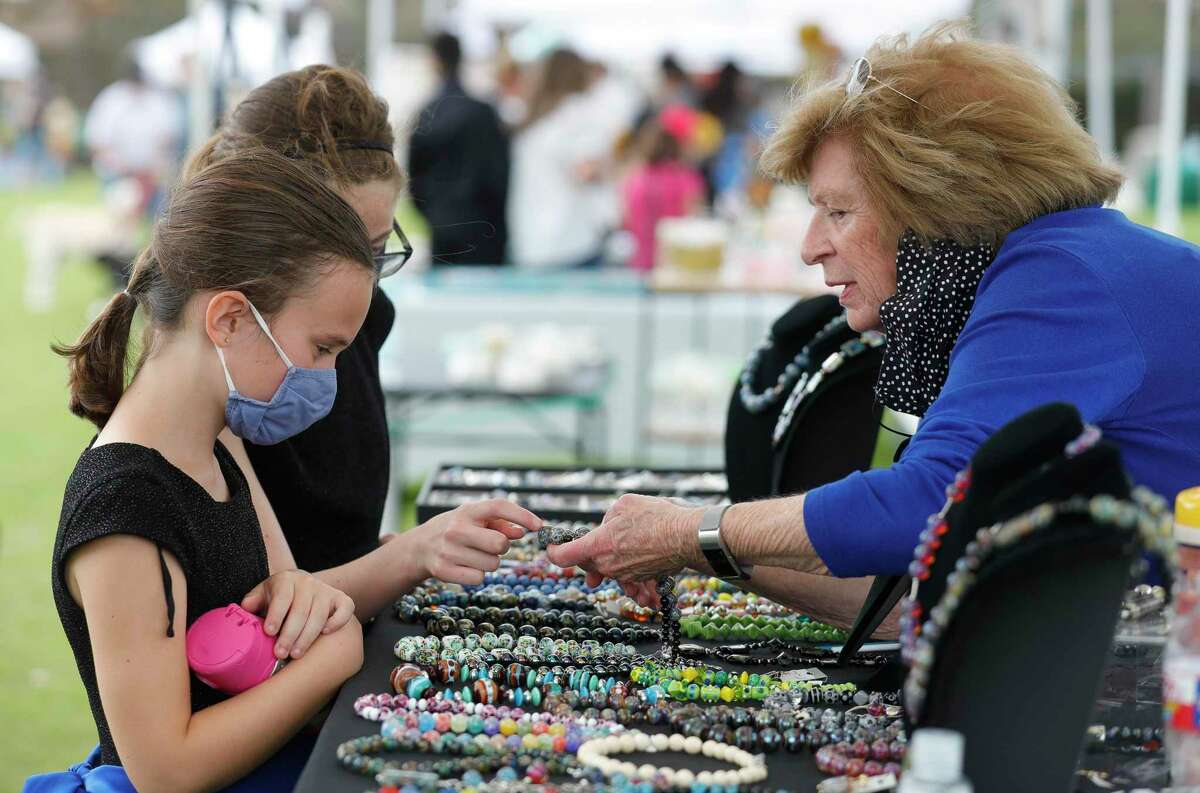 Sue Vogt shows Grace White and Brianna Robichaus handmade beads her husband made during Arts in the Park at Northshore Park, Saturday, March 13, 2021, in The Woodlands. This year’s Spring Break was all about families exploring outdoor events.