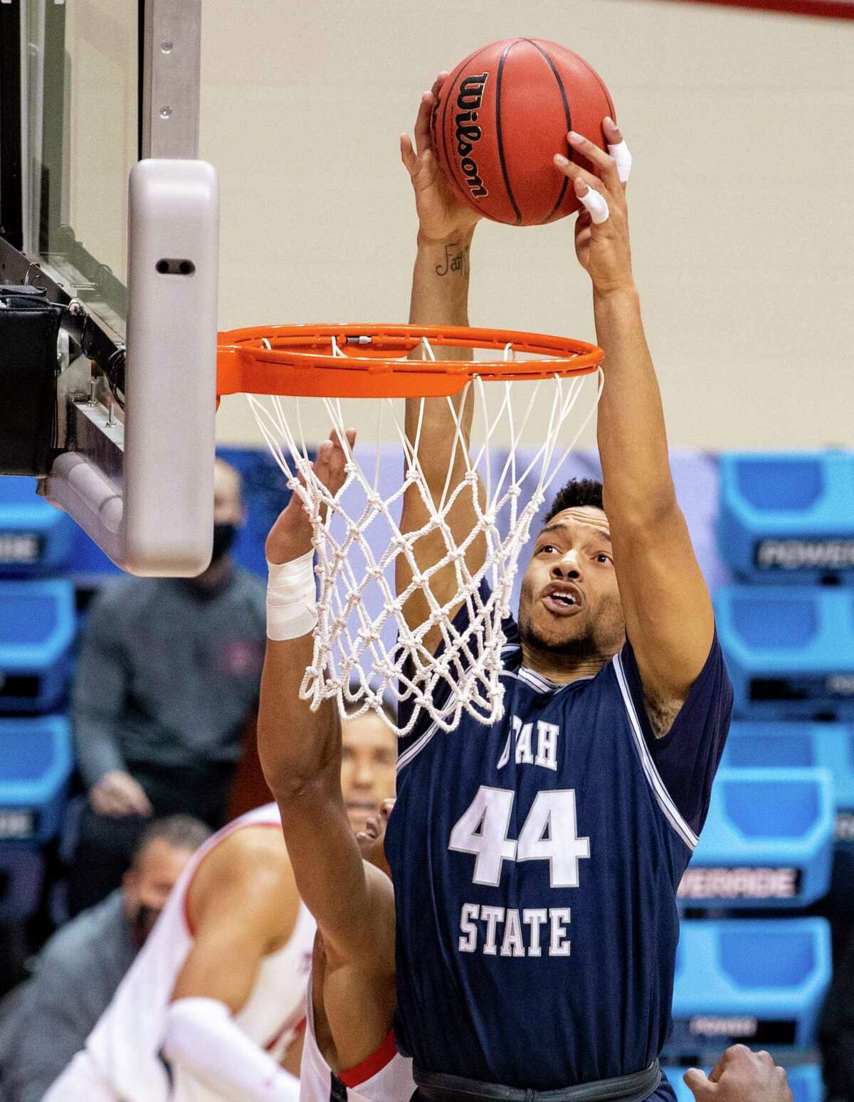 Utah State guard Marco Anthony (44) scores with a slam dunk during the first half of a first round game against Texas Tech in the NCAA men's college basketball tournament, Friday, March 19, 2021, in Bloomington, Ind. (AP Photo/Doug McSchooler)