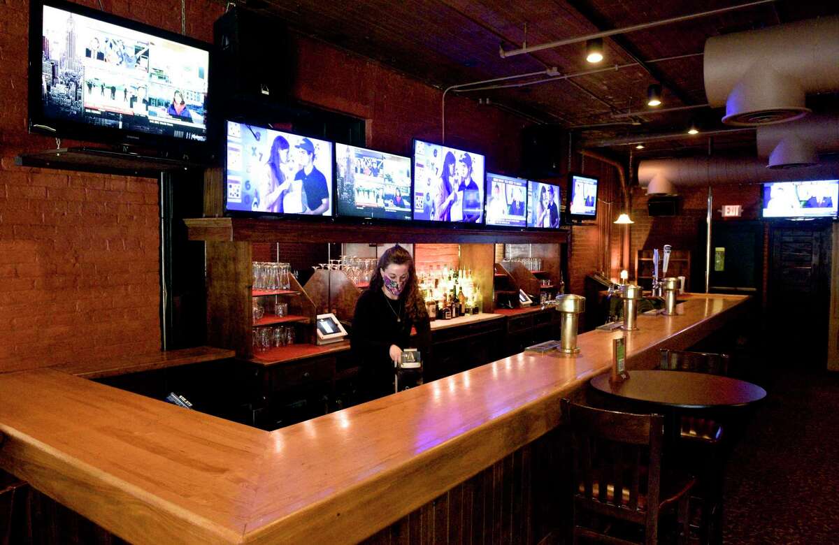 Sandra Mills, Assistant Manager/Bartender at Two Steps Downtown Grill restocks the bar on Friday afternoon. in March 19, 2021, in Danbury, Conn.