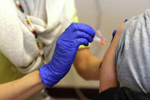 SEATTLE, WA - MARCH 15: Dr. Kim Vo, a pharmacist from the Seattle Indian Health Board, administers the first of two COVID-19 Moderna vaccine shots to staff from the Seattle Public Schools on March 15, 2021 in Seattle, Washington. The non-profit Seattle Indian Health Board held the event in partnership with Seattle Public Schools to administer the Covid-19 vaccine shots to school staff including special education teachers, instructional aides, custodians, and nutrition services staff. They wanted to ensure that the teachers and staff who need to work in close proximity with students were vaccinated. Seattle Indian Health Board was the first health facility in Washington state to receive and administer the Moderna vaccine. As of March 8, the organization has administered 5,156 shots according to a press release. (Photo by Karen Ducey/Getty Images)