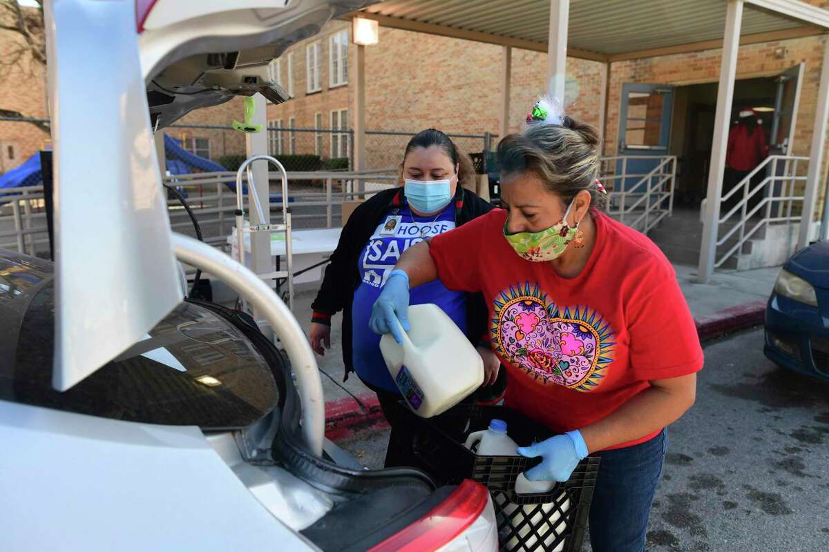 School employees load milk into a vehicle during a December nutrition drive at Washington Elementary School. A reader praises schools for feeding children throughout the pandemic.