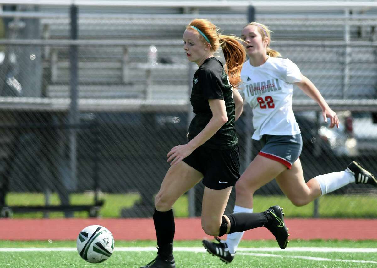 Kingwood Park freshman forward Emma Yeager pushes the ball upfield ahead of Tomball's Shelby Wiley (22) during their District 20-5A matchup at KPHS on Feb. 29, 2020.