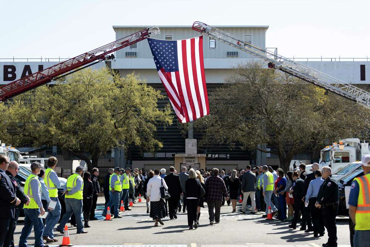 Tomball city workers form a walkway under the United States flag leading up to the entrance of Tomball High School Stadium during a celebration of life and remembrance service in honor of Tomball city manager, Robert Hauck, Friday, March 19, 2021, in Tomball. Hauck died in a one-car crash the previous Saturday, March 13.
