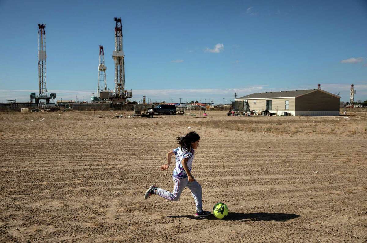 A child plays near a storage yard in West Odessa. The number of drilling rigs operating in the U.S. fell for the first time in six weeks as crude supplies increased in the U.S. and coronavirus cases rose in Asia, putting a damper on oil’s recovery. 