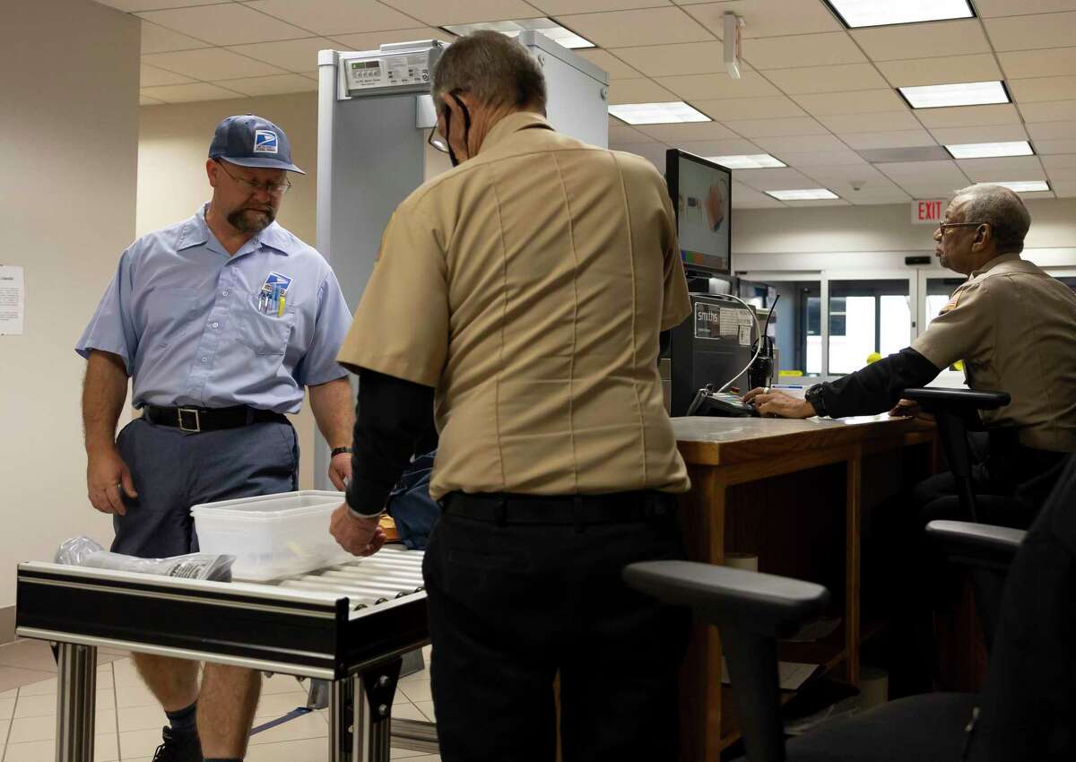A USPS mail courier goes through security at the Lee G. Alworth Building, Thursday, March 18, 2021, in Conroe. In-person jury duty cases have been held inside the courtrooms despite the ongoing COVID-19 pandemic.