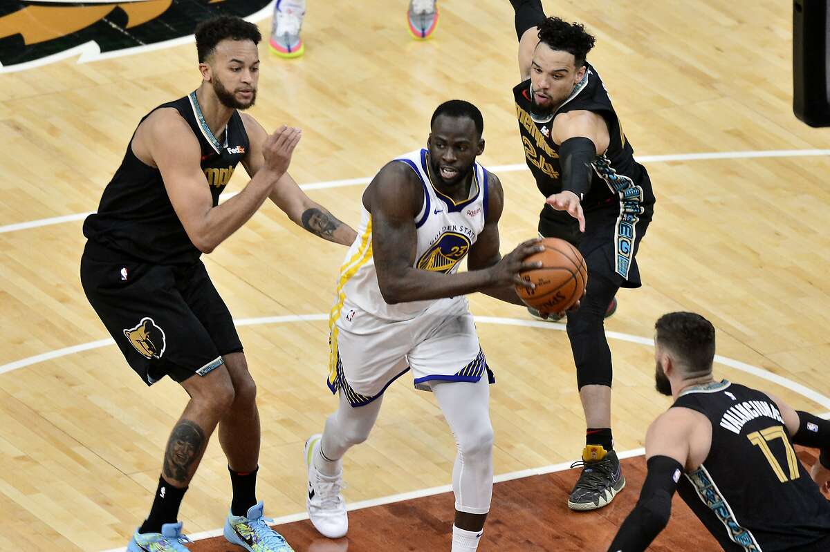Golden State Warriors forward Draymond Green (23) handles the ball between Memphis Grizzlies forwards Dillon Brooks (24) and Kyle Anderson (1) in the second half of an NBA basketball game Friday, March 19, 2021, in Memphis, Tenn. (AP Photo/Brandon Dill)