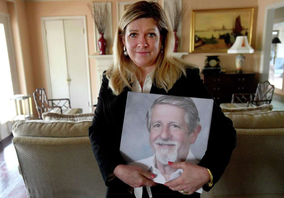 Kathy Thomas holds a photo of her husband, Dr. George Thomas, who died Dec.12 from COVID-19. Dr. Thomas treated coronavirus patients from the onset of the pandemic in the area, believing it was a time when his skills were needed more than ever before. The family plans a memorial service later in the spring. Photo made Saturday, March 20, 2021 Kim Brent/The Enterprise
