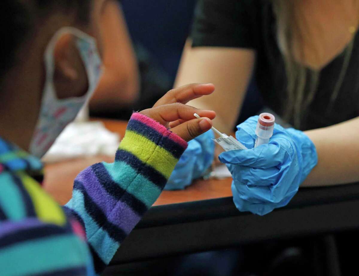 A young student prepares to swab her nose for the Covid-19 test. Community Labs provided weekend COVID-19 testing as some schools prepare to return to class after spring break on Sunday, March 14, 2021.