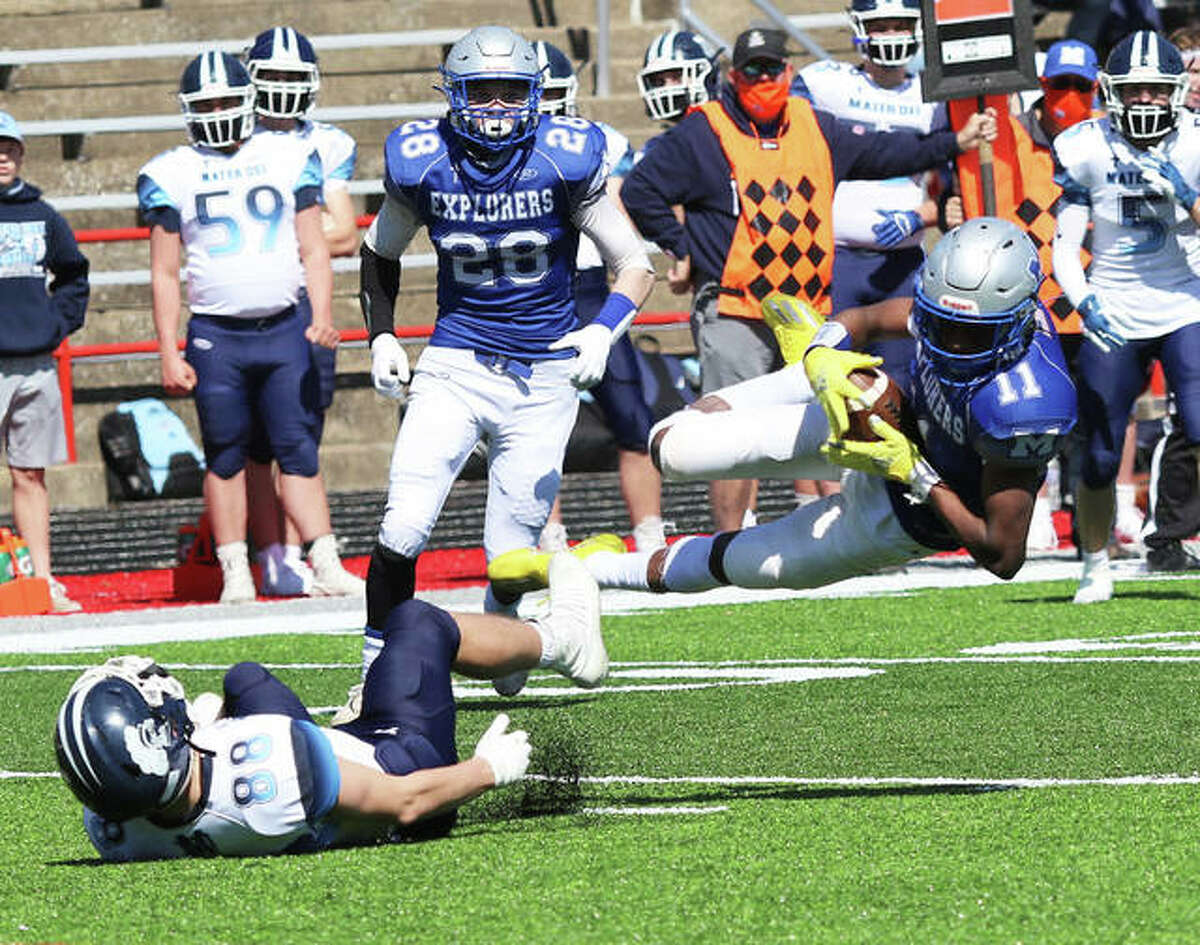 Marquette Catholic’s Devon Fields (11) makes a diving attempt at a catch after beating Breese Mater Dei’s Mitchell Haake (88) to the football as the Explorers’ Alex Barnhart (28) watches the play on Saturday afternoon at Public School Stadium in Alton.