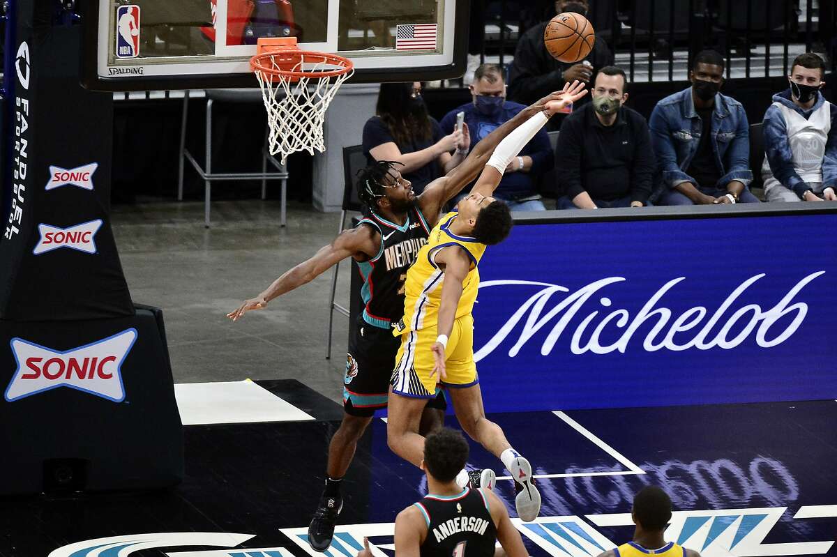 Golden State Warriors guard Jordan Poole, right, shoots against Memphis Grizzlies forward Justise Winslow in the first half of an NBA basketball game Saturday, March 20, 2021, in Memphis, Tenn. (AP Photo/Brandon Dill)