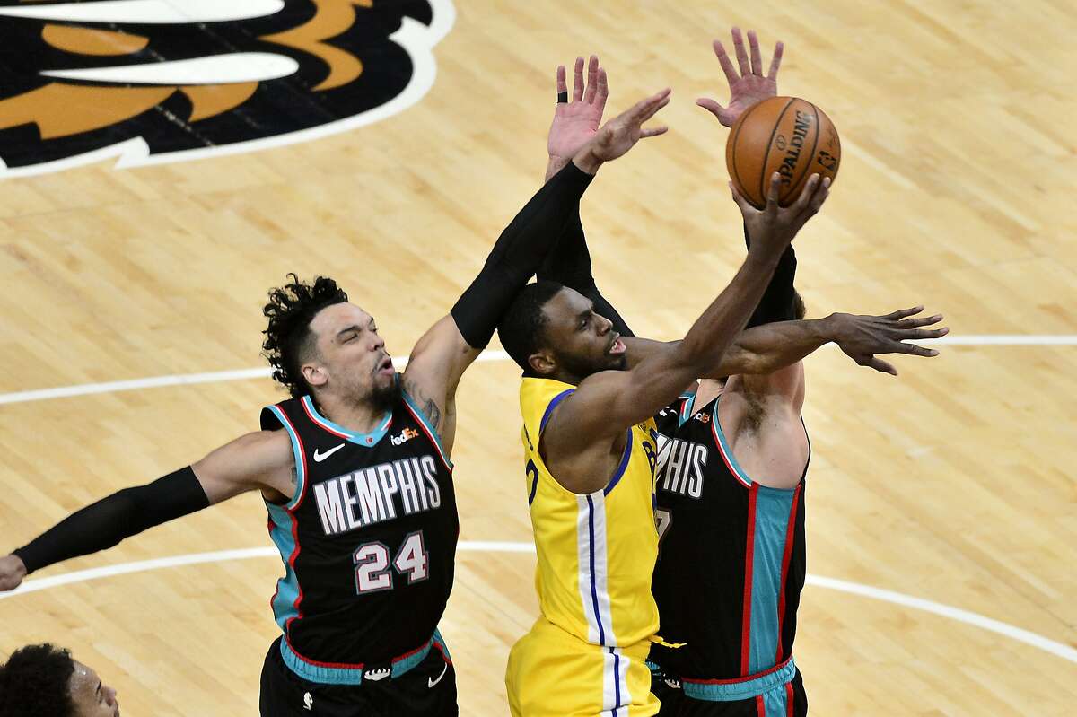 Golden State Warriors forward Andrew Wiggins shoots against Memphis Grizzlies forward Dillon Brooks (24) and center Jonas Valanciunas in the second half of an NBA basketball game Saturday, March 20, 2021, in Memphis, Tenn. (AP Photo/Brandon Dill)