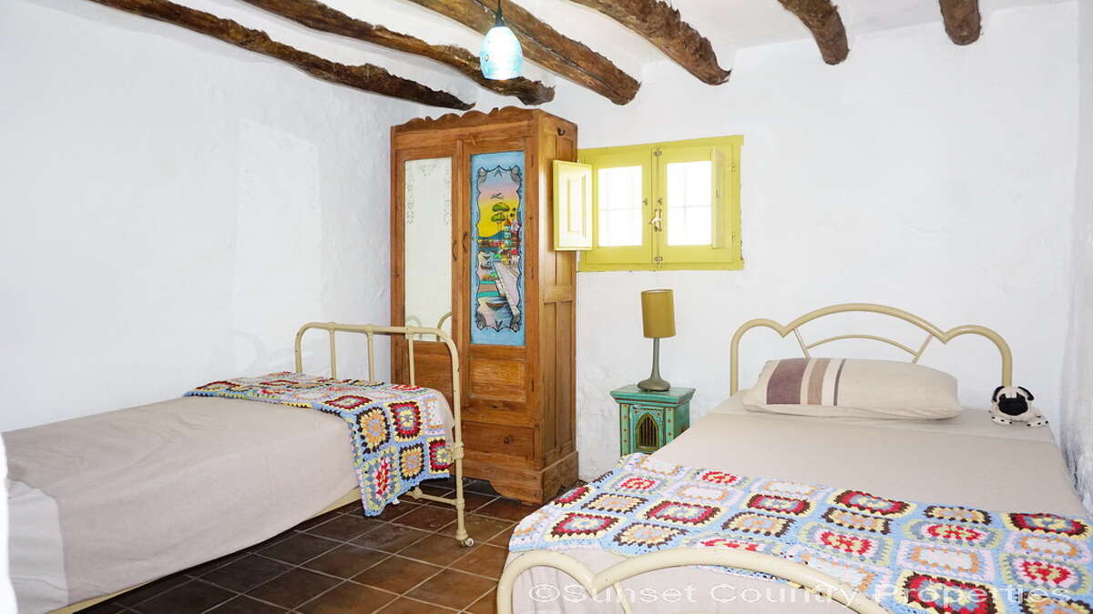 Terracotta tile floors, exposed wooden beams, and yellow-trimmed windows - all for a low, low price