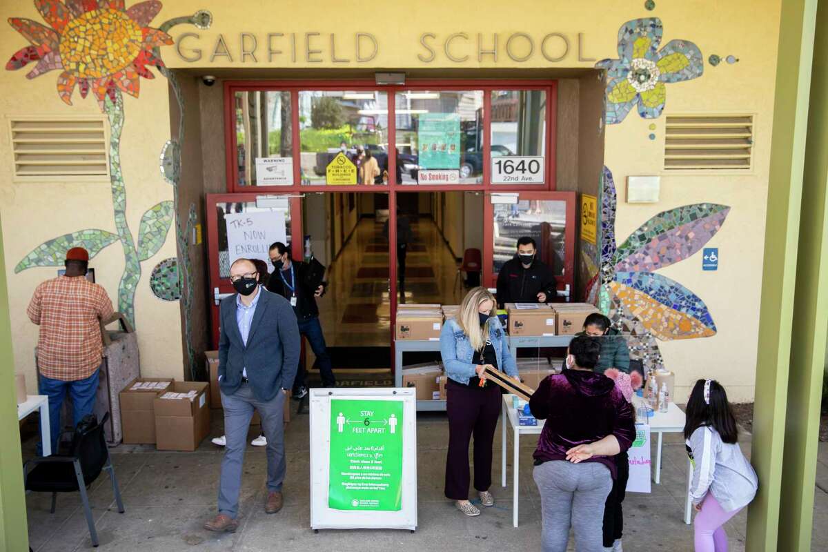Parents and students arrive outside of Garfield Elementary School in Oakland this month to receive their laptops for distance learning.