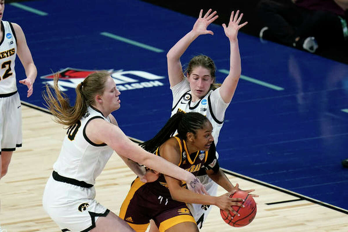 Central Michigan guard Anika Weekes, center, drives between Iowa center Sharon Goodman, left, and guard Kate Martin, right, during the second half of a college basketball game in the first round of the women’s NCAA tournament at the Alamodome, Sunday, March 21, 2021, in San Antonio.