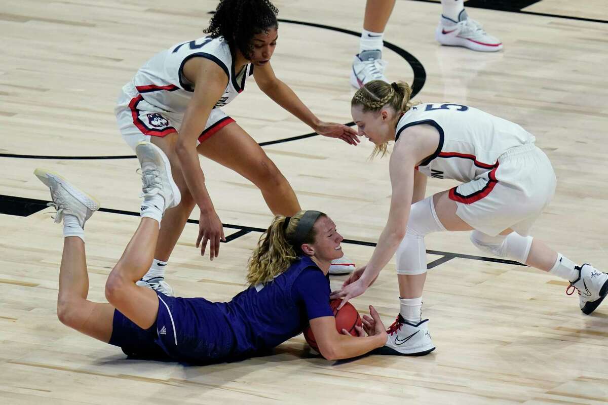 High Point guard Jenson Edwards, center, dives for a loose ball against UConn guard Evina Westbrook, left, and guard Paige Bueckers during the first half at the Alamodome in San Antonio on Sunday.