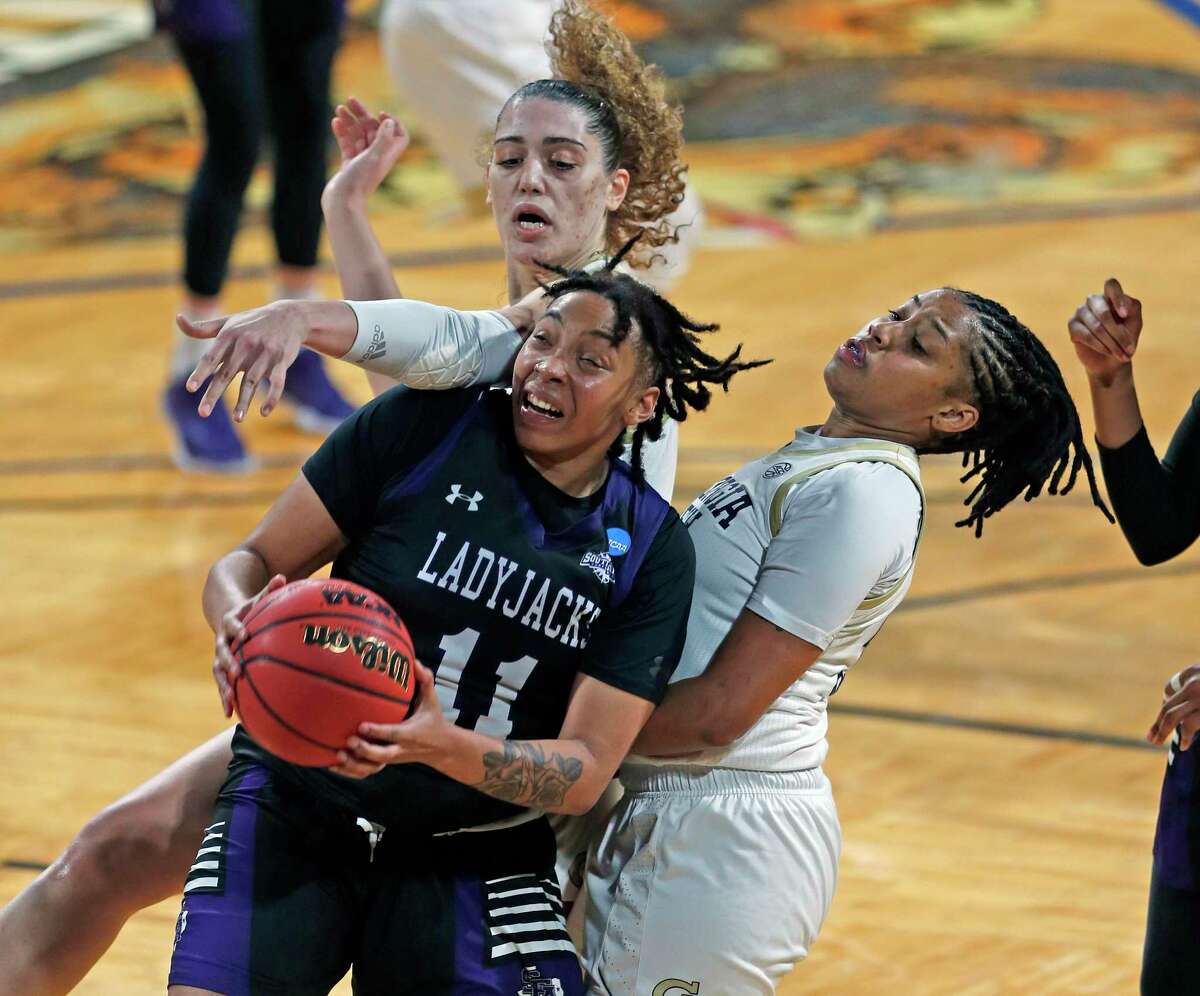 Stephen F. Austin forward Avery Brittingham (11) battles Georgia Tech defenders during the second half of a college basketball game in the first round of the women's NCAA tournament at the Greehey Arena in San Antonio, Texas, Sunday, March 21, 2021. (AP Photo/Ronald Cortes)